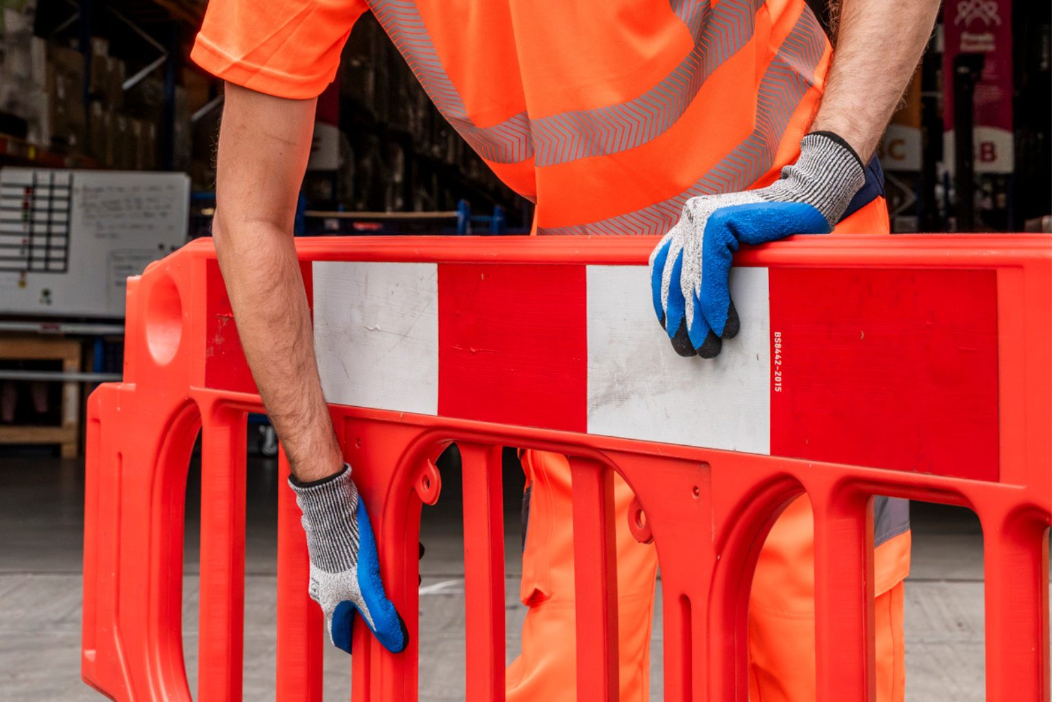 Man wearing orange hi-vs workwear and safety gloves.