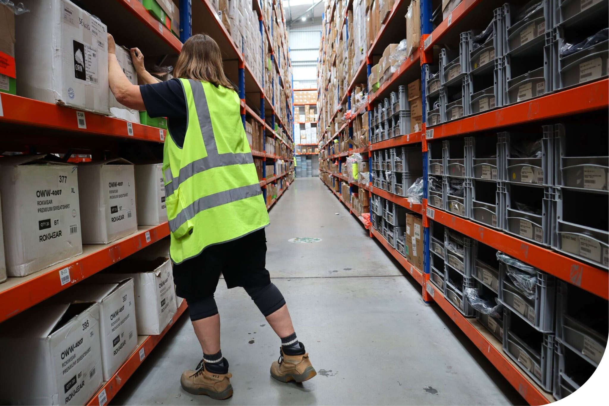 Woman wearing hi-vis inside a warehouse.