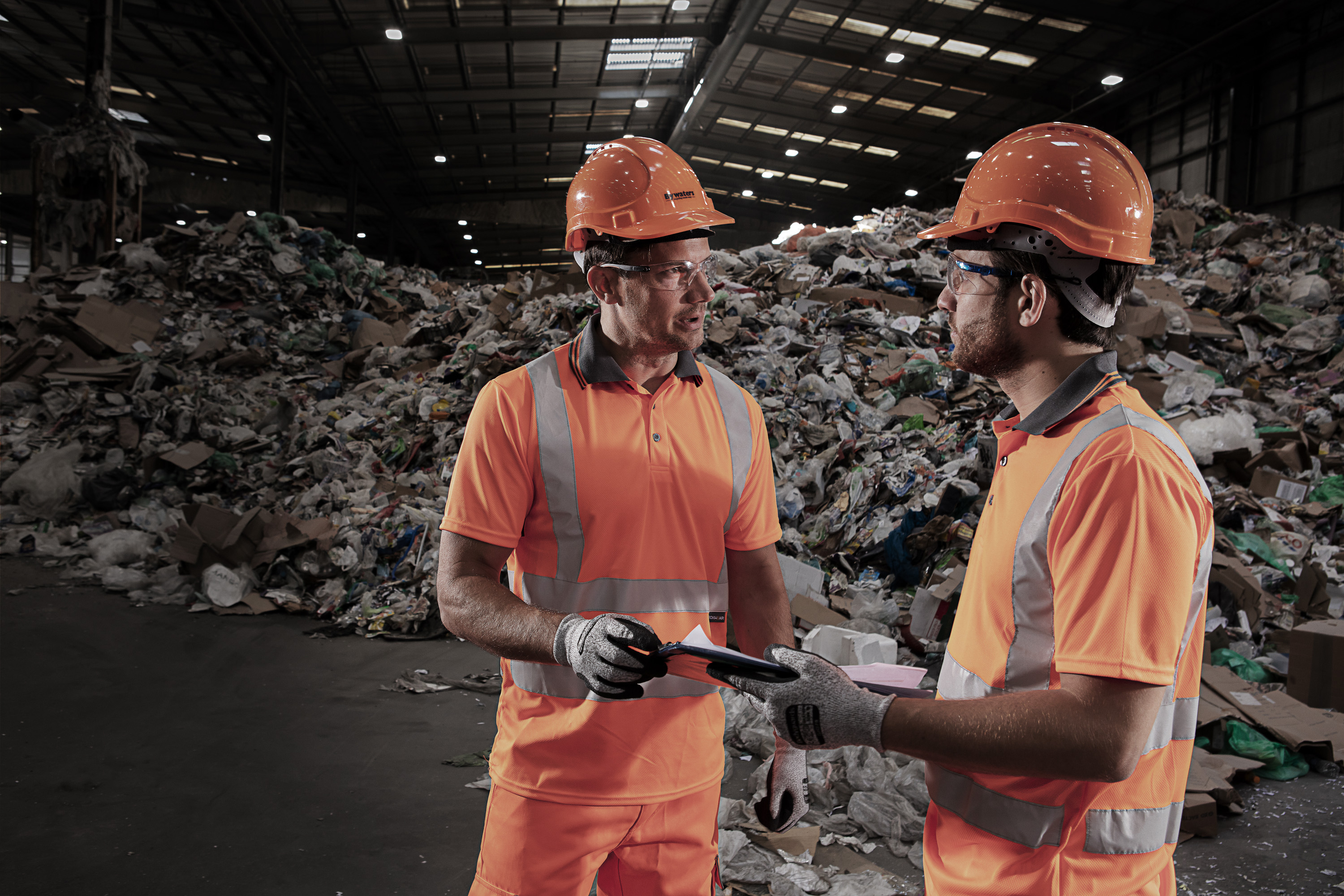 Two workmen onsite holding clipboard
